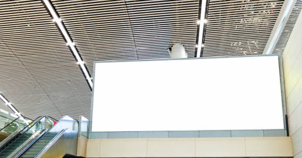 rohes plakat neben rolltreppe am flughafen - subway station billboard poster billboard posting stock-fotos und bilder