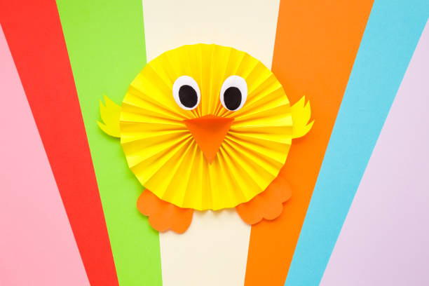 istock Happy yellow chick folded and created from paper on colorful background. Top view. 1137553893