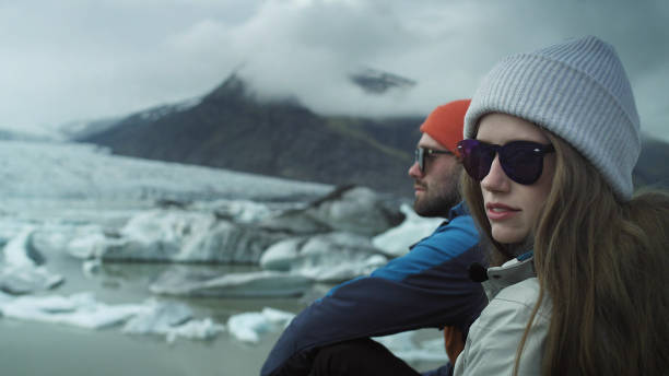 Glacier lagoon. Couple relaxing on a lagoon shore