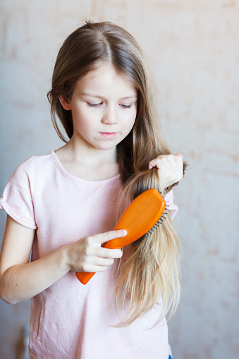 A Little Girl Combing Her Long Hair Stock Photo - Download Image Now - Comb  - Hair Care, Combing, Girls - iStock