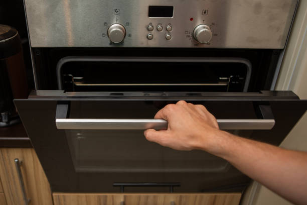 istock Photo of oven and human hand 1137563114