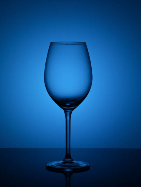 istock empty glass of glass stands on the mirror surface on a blue background 1137563740