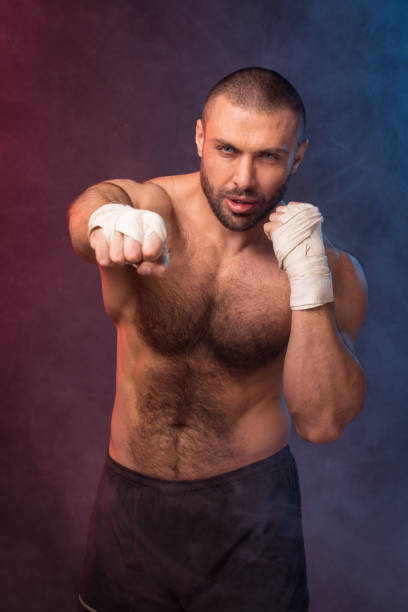 istock Young muscular boxing fighter training kicks. Kickboxer making a fighting exercise. 1137564368