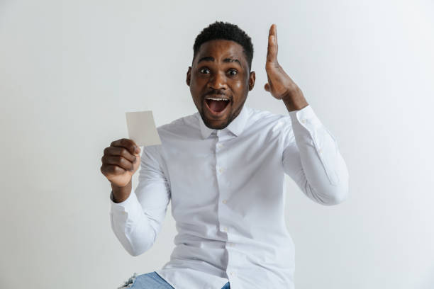 istock Young afro man with a surprised happy expression won a bet on gray studio background. 1137565822