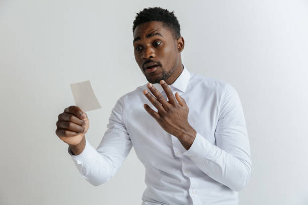 Young afro man with a disappointed unhappy sad expression lost a bet on gray studio background.