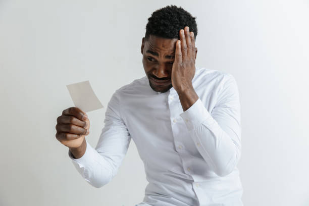 istock Young afro man with a disappointed unhappy sad expression lost a bet on gray studio background. 1137565835