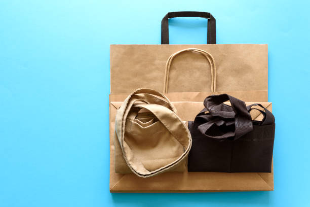 istock Brown empty kraft paper and linen case bags on blue background. Top view. Eco packaging or packaging of meals concept 1137566501