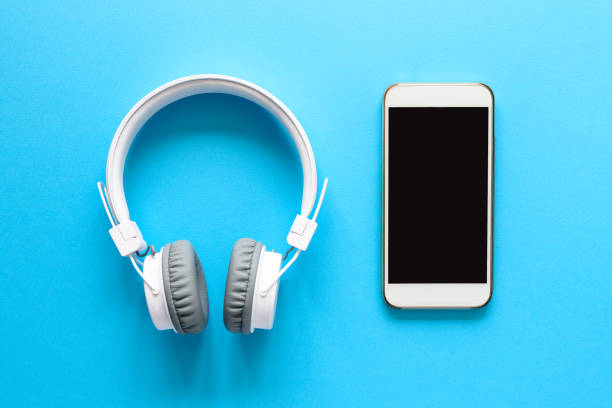 istock White wireless headphones and smart phone on blue background. Top view. Copy space 1137566561
