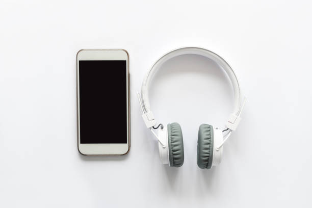 istock White wireless headphones and smart phone on white background. Top view. Copy space 1137566563