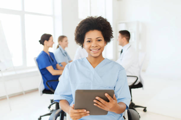 istock happy nurse with tablet pc over team at hospital 1137568025