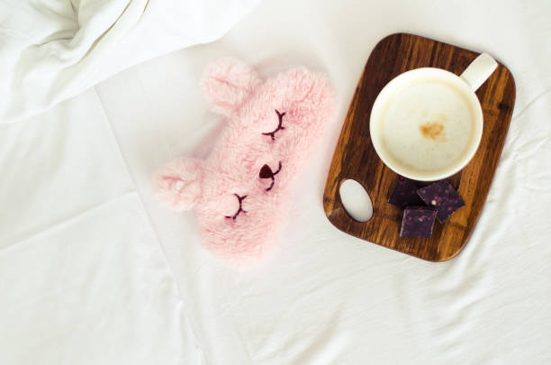 istock Cup of coffee with cute pink sleep mask 1137569672