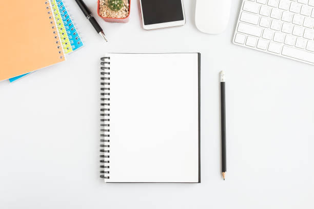 istock Top view, empty notebook and office supplies on the desk. 1137571479