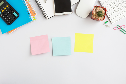 Top view office desk with smartphone, computer and office supplies  with sticky note