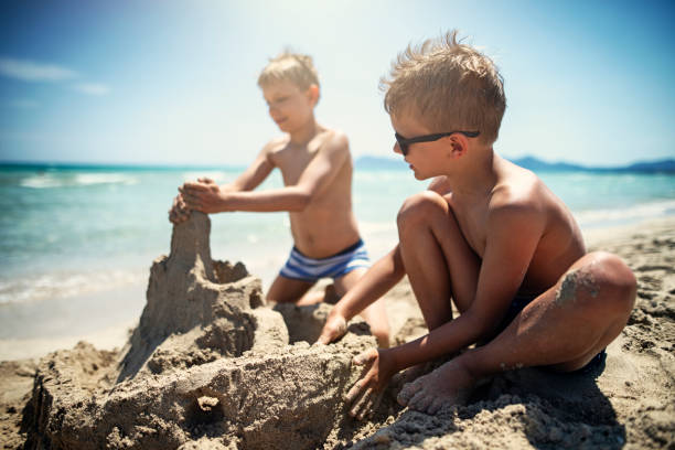 istock Little boys building a sandcastle on beach 1137572795