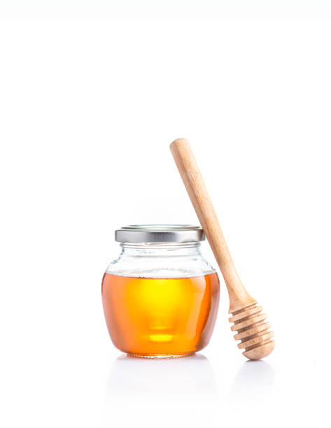 밀폐 된 뚜껑 유리 항아리와 꿀이 있는 꿀은 항아리에 기대어, 모든 흰색 배경에 복사 공간에 - syrup jar sticky isolated objects 뉴스 사진 이미지