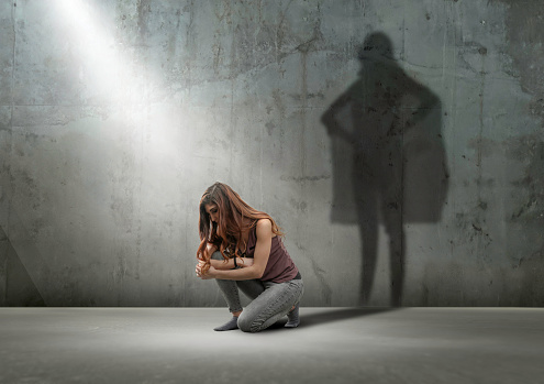 Woman crouching with shadow as super hero