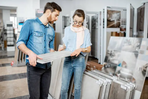 Photo of Couple choosing ceramic tiles in the shop