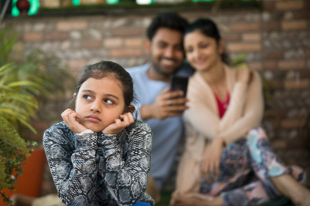 istock Bored girl with parents using mobile phone 1137586709