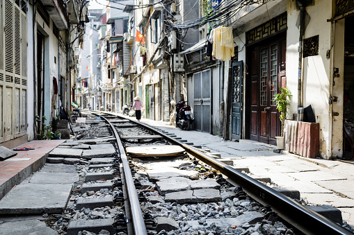 Detail of the railroad tracks in its haven district of Hanoi Station. Men and women sharing their daily activity with the passage of trains