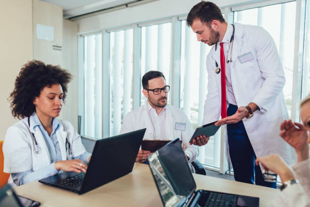 istock Medical team sitting and discussing at the table in the office, using digital tablet. 1137596583