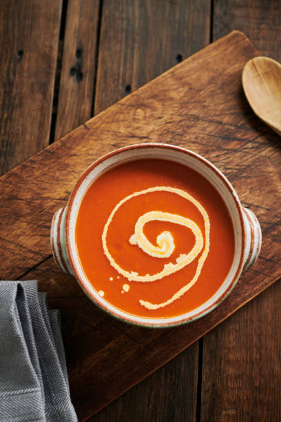 crema de sopa de tomate cubierta con un remolino de crema. - sopa de tomate fotografías e imágenes de stock