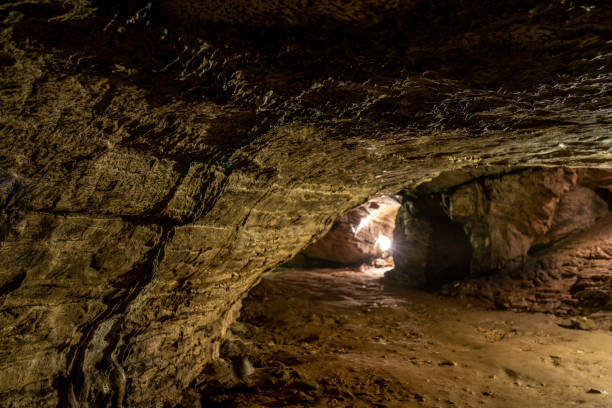 istock View inside the ancient cave with stone walls with additional lighting. Texture of a stone wall in a cave. 1137597679