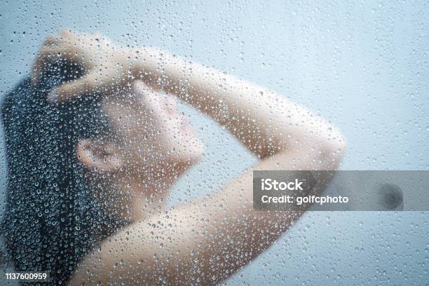 Women Talking A Shower Behind Glass Windows In The Shower Room Stock Photo - Download Image Now