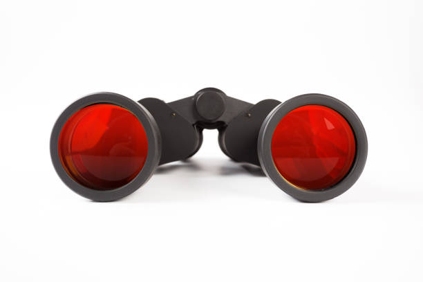 istock Black binoculars with orange lens isolated on white background 1137602010