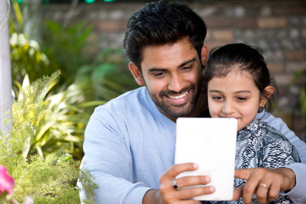 istock Father and daughter using digital tablet at porch 1137602802