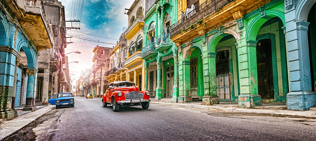 Vintage red oldtimer car driving through Havana Cuba