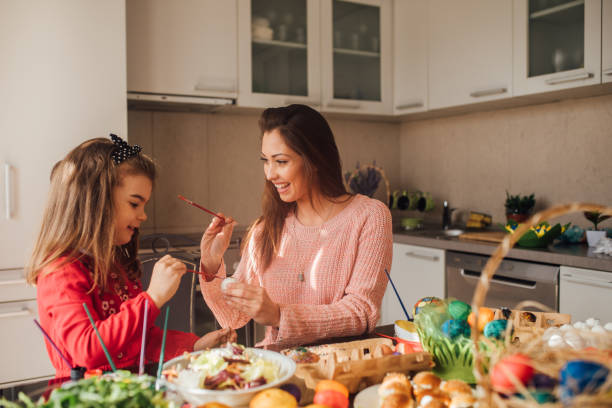 istock Woman decorating Easter eggs with daughter and smiling 1137604360