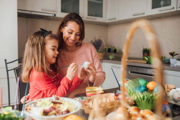 istock Woman decorating Easter eggs with toddler daughter 1137604417