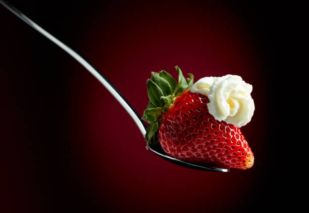 istock Strawberry with whipped cream in spoon on a dark background. 1137618458