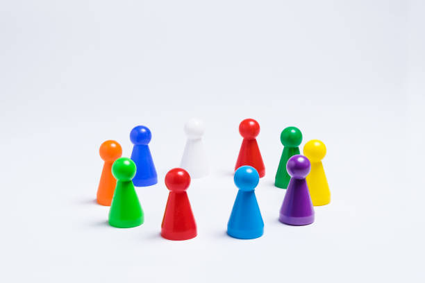 Group of colored pawns arranged in a circle on a white background stock photo