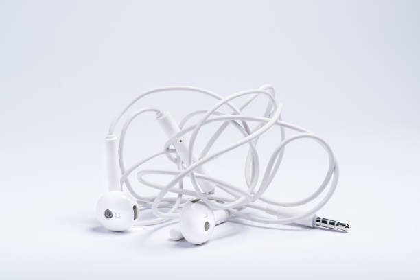 белые наушники для прослушивания музыки с плетеным шнуром изолированы на белом фоне - cable intertwined nobody technology стоковые фото и изображения