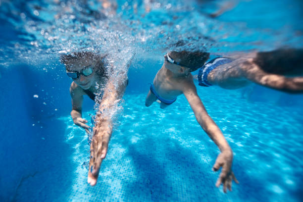 istock Kids swimming race in pool 1137619715