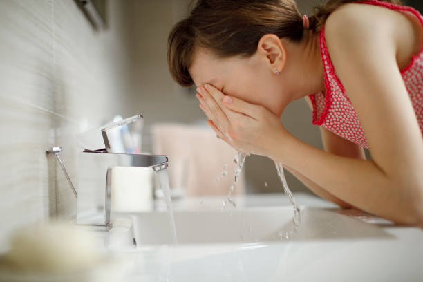 istock Young woman washing her face 1137620099