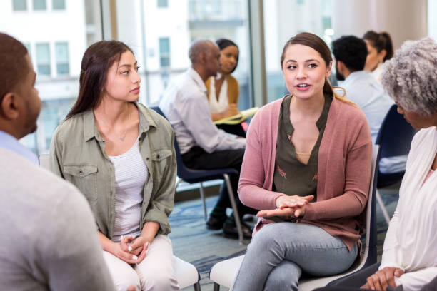 istock Young woman speaks during group therapy 1137620276