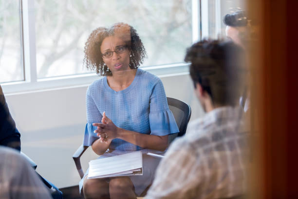 istock Mature female counselor speaks during group therapy session 1137620318