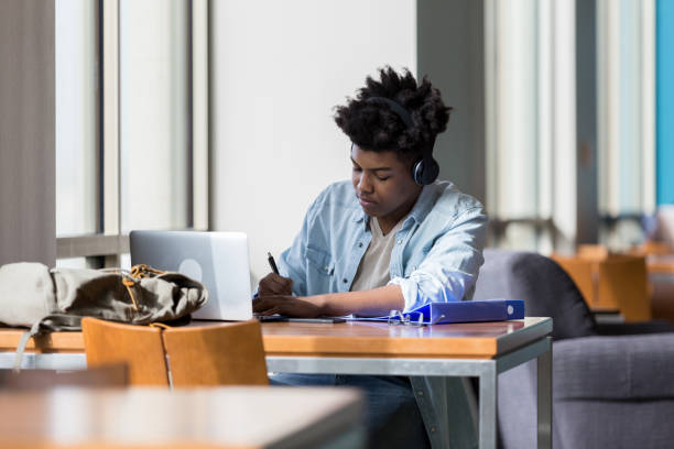 istock Teenage boy studies in school library 1137620336