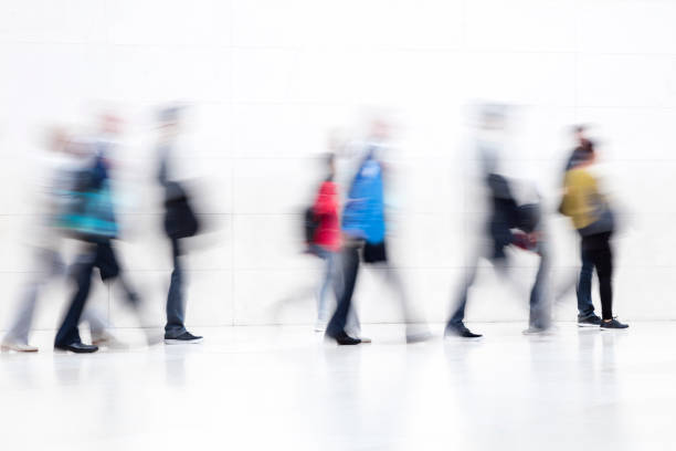 large group of people walking on white hallway, motion blur effect - airport interior imagens e fotografias de stock