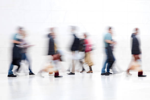 istock Group of People Walking on White Hallway, Motion Blur Effect 1137623035