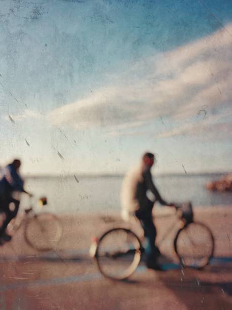 istock Defocused textured view of two cyclists on the coastline 1137623999