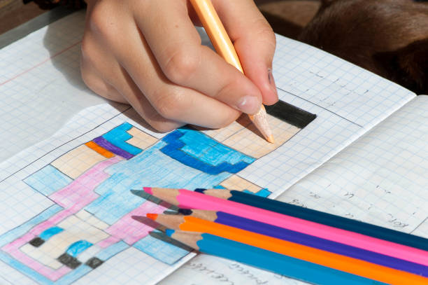 Child hand draws the multicolored minecraft picture. Outdoors close-up horizontal image