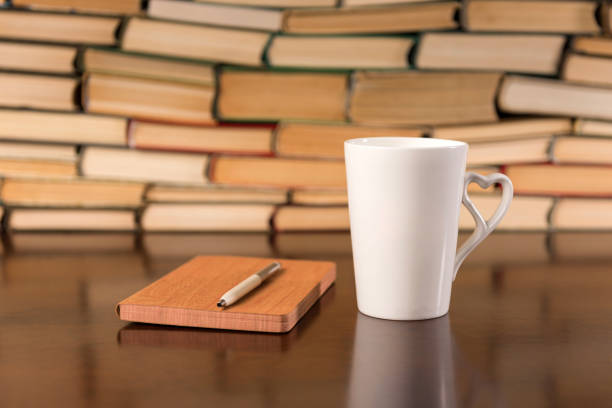 istock Old books on wooden table with tea and open notebook 1137626320