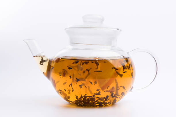 istock Glass teapot with black tea nad fresh orange isolated on white background 1137626371