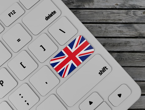 English flag enter key on white keyboard, on wood background. 3d render