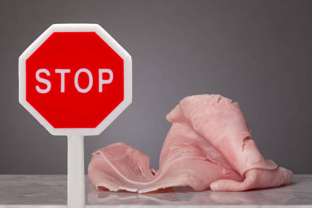 Do not eat meat A piece of boiled ham laying on a marble plate. In front a stop sign dont eat meat stock pictures, royalty-free photos & images