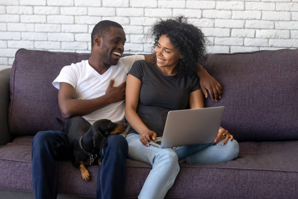 istock Laughing African American couple using laptop together at home 1137632809