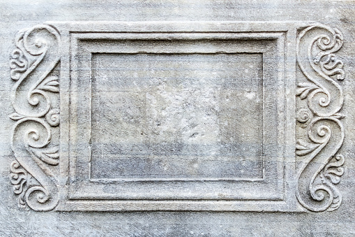 Close-up of rectangular frame with engraved ornament on ancient stone sarcophagus in a public park next to the Archaeological Museum in Varna. Tourist attractions and landmarks.